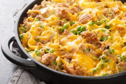 Prato com macarrão com queijo gratinado por cima numa bancada.