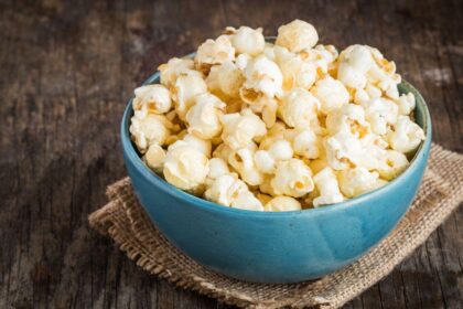 Cumbuca com pipoca em cima de uma mesa.