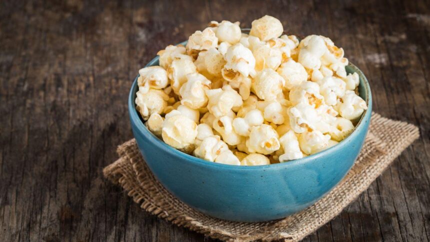 Cumbuca com pipoca em cima de uma mesa.