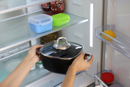 Imagem de uma pessoa colocando uma panela dentro da geladeira