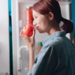 Imagem de uma mulher conferindo se uma maçã está boa após tirá-la da geladeira
