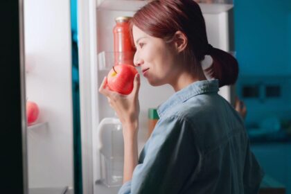 Imagem de uma mulher conferindo se uma maçã está boa após tirá-la da geladeira