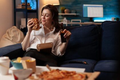 Imagem de uma mulher comendo comidas de delivery