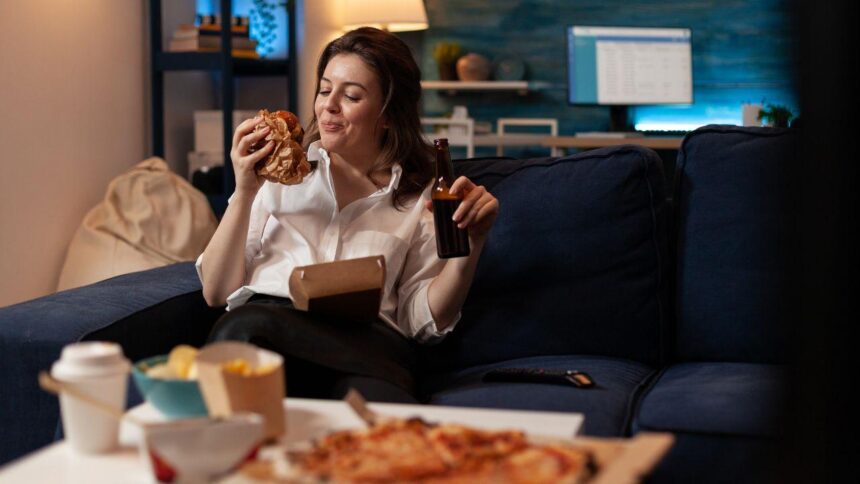 Imagem de uma mulher comendo comidas de delivery