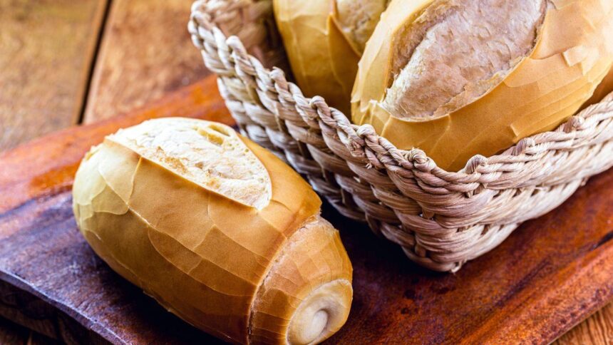 Pão francês dentro da cesta em cima de uma mesa.