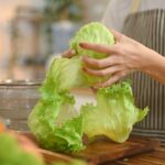 Imagem de uma pessoa lavando alface