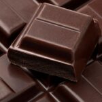 Imagem mostra chocolate em barra empilhados um por cima do outro.