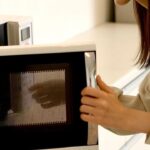 Imagem de uma pessoa colocando algo no micro-ondas