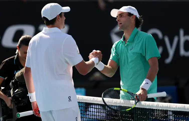 Reuters/Edgar Su/Proibida reprodução Tennis - Australian Open - Melbourne Park, Melbourne, Australia - January 20, 2026 Eliot Spizzirri of the U.S. shakes hands with Brazil's Joao Fonseca after winning his first round match REUTERS/Edgar Su