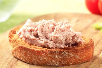 Mostra torradas com patê de atum em cima de uma mesa.