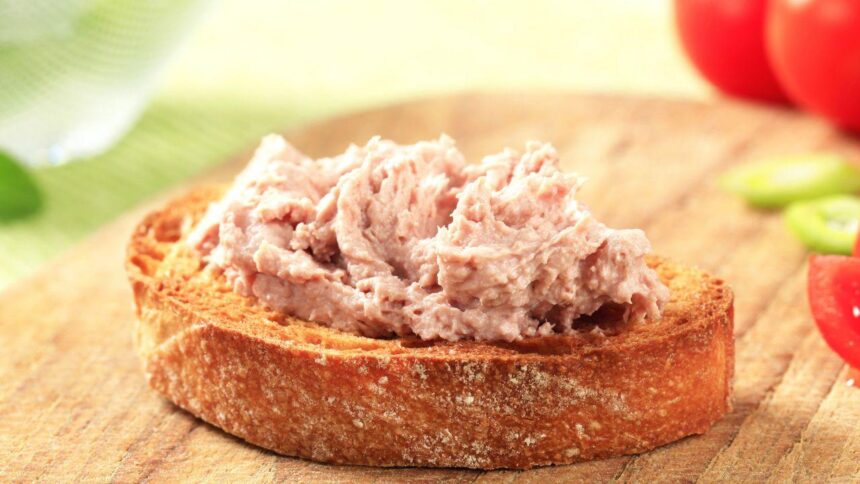 Mostra torradas com patê de atum em cima de uma mesa.