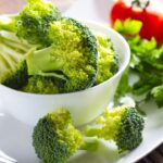 Imagem de um pote pequeno branco de cerâmica com pedaços de brócolis dentro