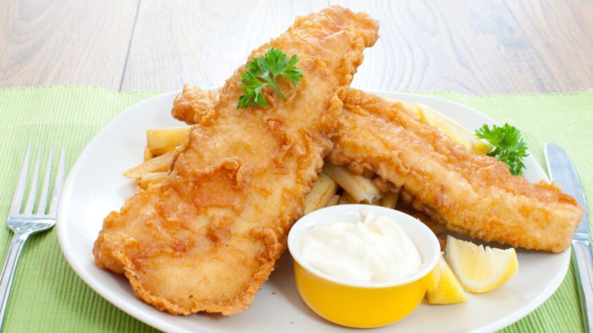 Filés de peixe frito dentro de um prato com pote de maionese ao lado.