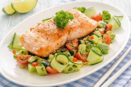 Imagem de um salmão grelhado em um prato com salada embaixo