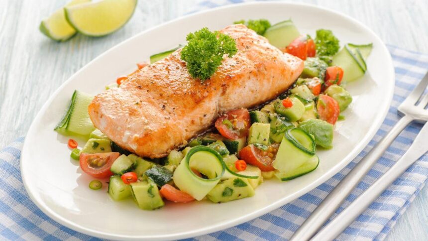 Imagem de um salmão grelhado em um prato com salada embaixo