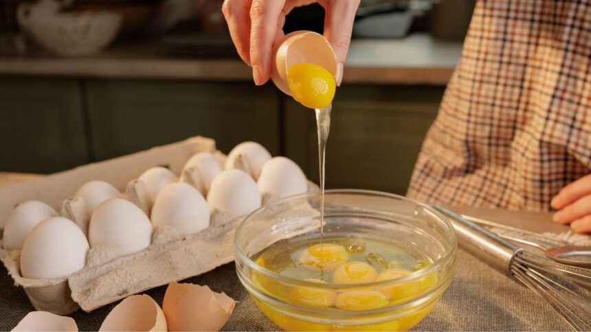Imagem de uma pessoa quebrando ovos em um recipiente de vidro
