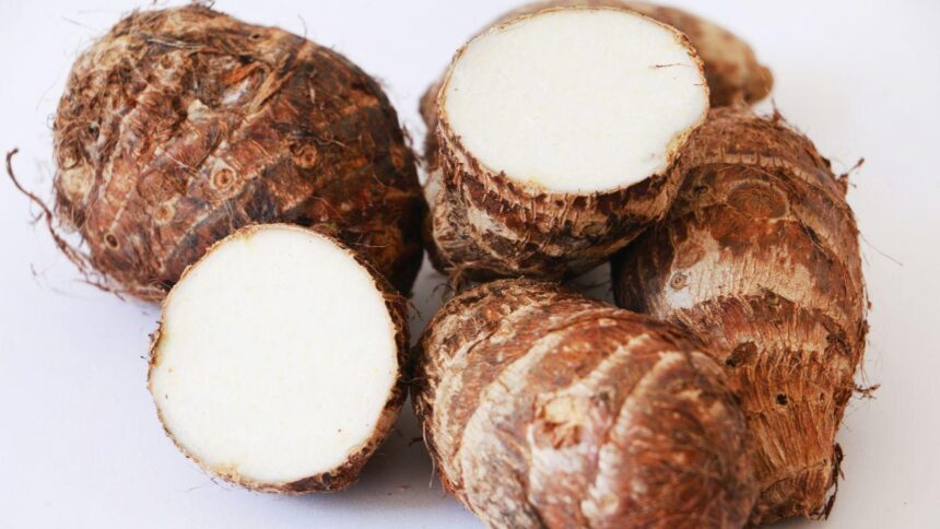 Foto mostra três inhames em cima de uma mesa cortados.