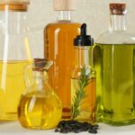 Foto mostra frascos de óleo um ao lado do outro em cima da mesa.
