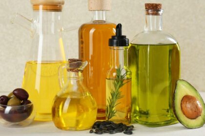 Foto mostra frascos de óleo um ao lado do outro em cima da mesa.