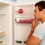 homem olhando a geladeira