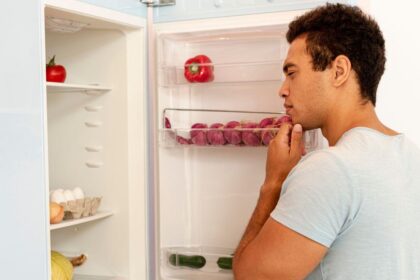 homem olhando a geladeira