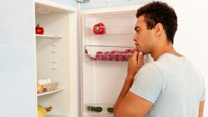 homem olhando a geladeira