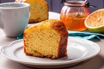 Imagem de uma fatia alta e fofinha de bolo de laranja