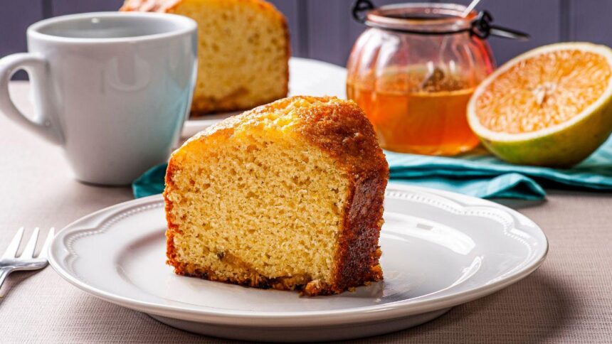 Imagem de uma fatia alta e fofinha de bolo de laranja