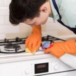 Homem na cozinha limpando o fogão