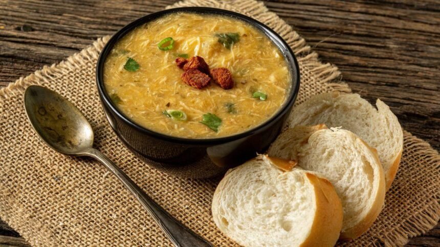 Imagem de um pote com sopa e fatias de pão ao lado