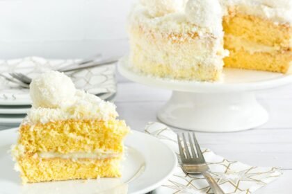 Foto mostra pedaços de bolo de coco em fatias em cima de uma bandeja.