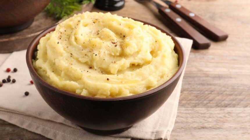 Imagem de uma porção de purê de batata em um pote marrom escuro