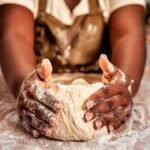 Imagem de uma mulher sovando uma massa