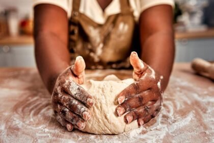 Imagem de uma mulher sovando uma massa