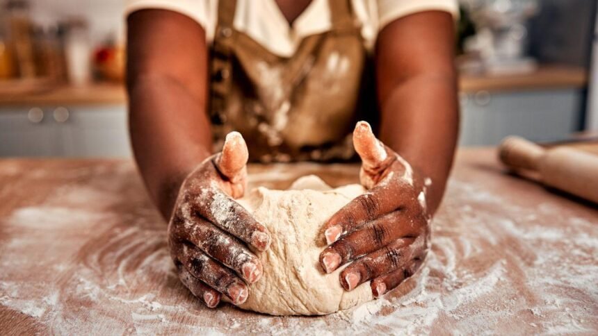 Imagem de uma mulher sovando uma massa