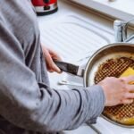 Imagem de uma pessoa lavando uma panela