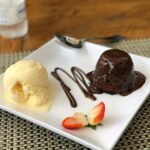 Foto mostra um prato de porcelana com um Petit Gâteau.