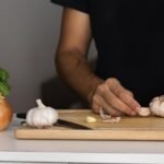 pessoa cortando cebola e alho