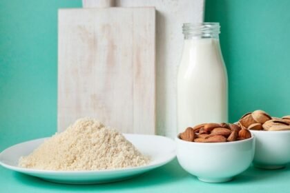 Imagem de um prato pequeno com farinha de amêndoas e uma porção de amêndoas ao lado