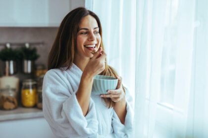 Imagem de uma mulher tomando café na cozinha