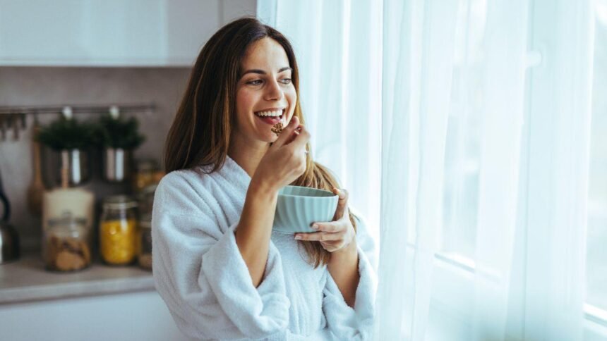 Imagem de uma mulher tomando café na cozinha