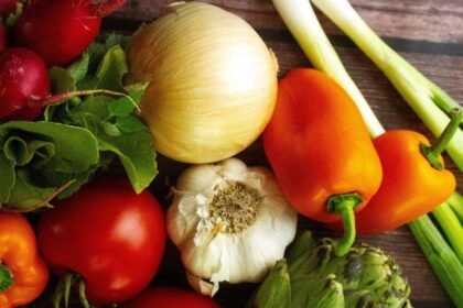 Imagem de vários alimentos juntos, contendo alho, cebola e tomate