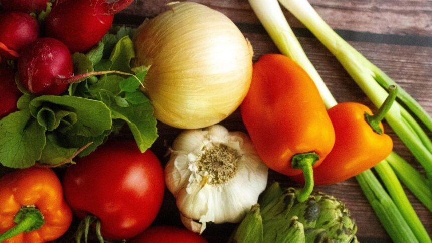 Imagem de vários alimentos juntos, contendo alho, cebola e tomate