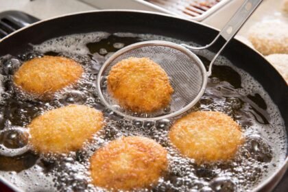 Imagem de bolinhos sendo fritos em uma frigideira com óleo