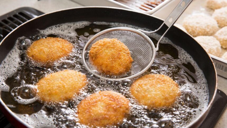 Imagem de bolinhos sendo fritos em uma frigideira com óleo