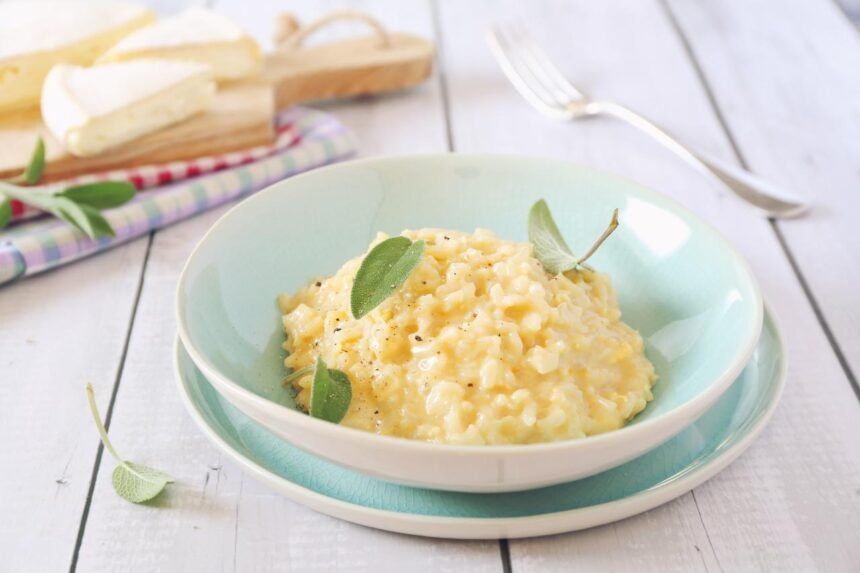 Risoto de queijo dentro de um prato em cima da mesa.