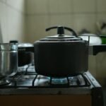 Panela de pressão e canecão em cima do fogão