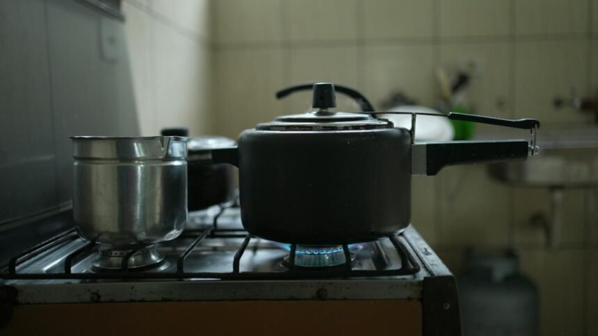 Panela de pressão e canecão em cima do fogão