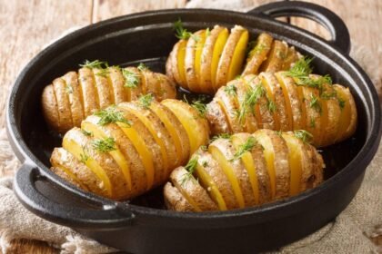 Imagem de batatas assadas em uma assadeira preta redonda