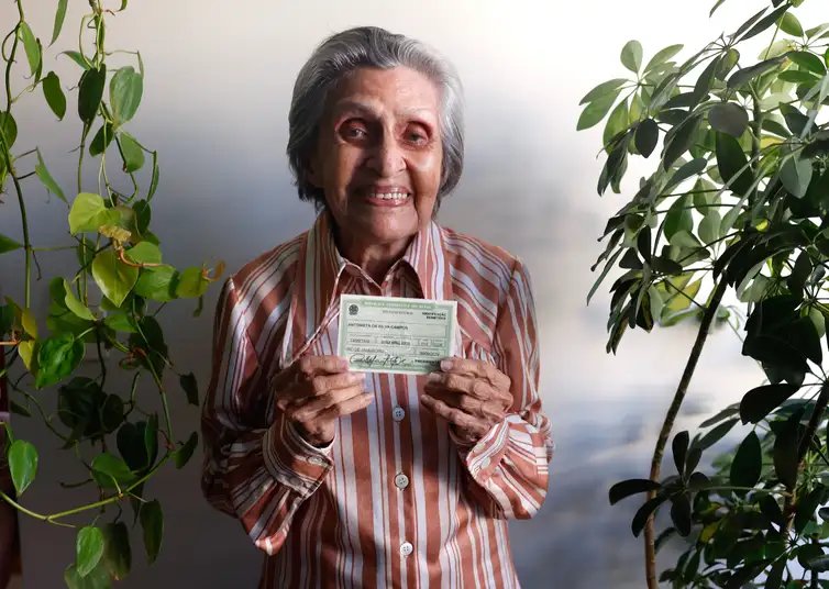 Tânia Rêgo/Agência Brasil Rio de Janeiro (RJ), 10/07/2026 - Antonieta da Silva Campos, 96 anos, bancária aposentada, exibe seu título de eleitor em sua casa. Foto: Tânia Rêgo/Agência Brasil